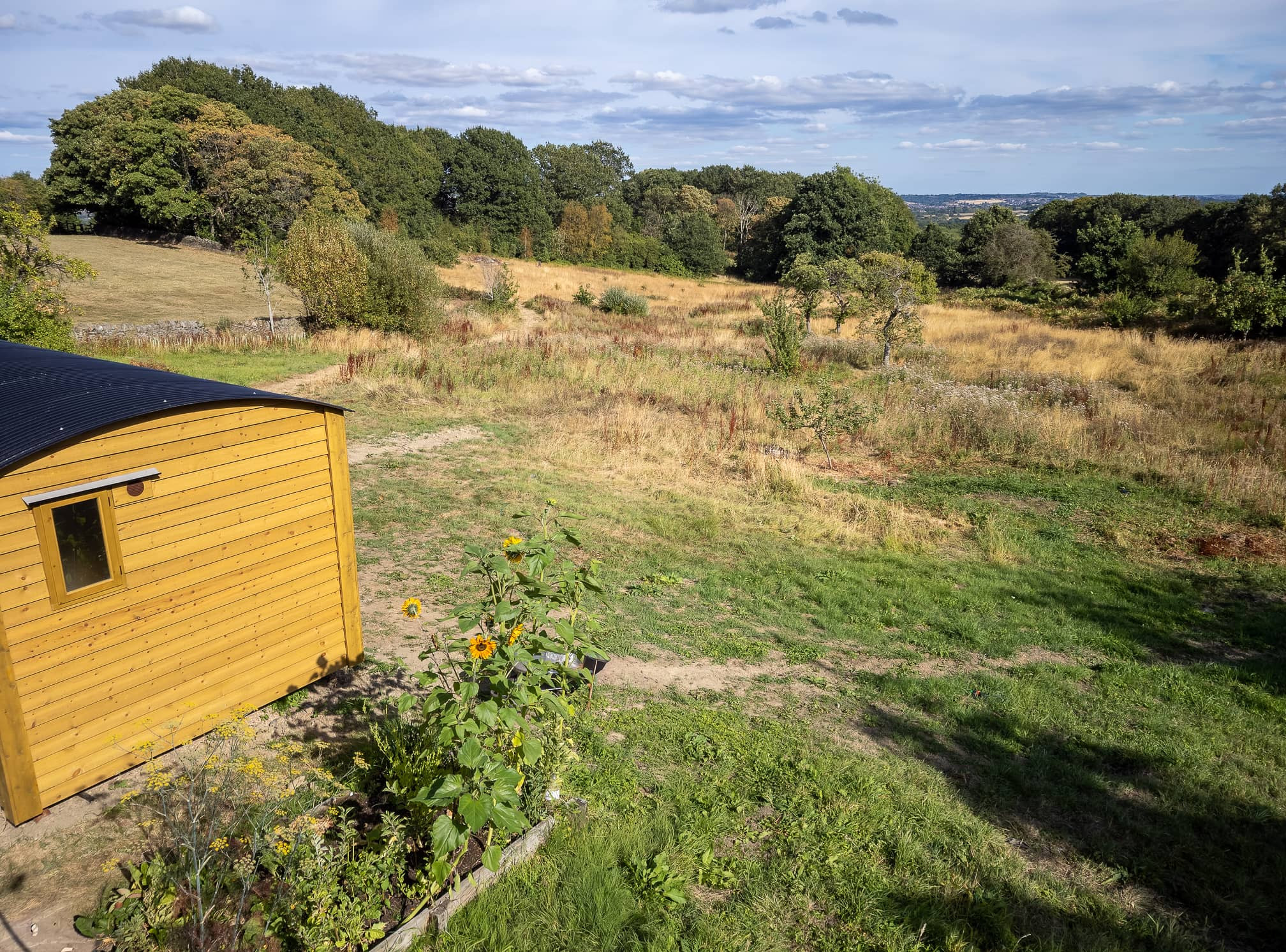 Exterior daytime view of the wooden shepherd's hut and its iron wheels